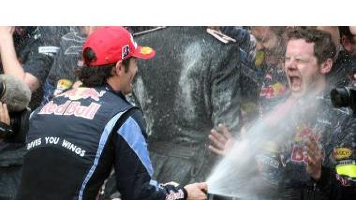 Mark Webber rocía a sus mecánicos con champán tras adjudicarse el GP de Mónaco.