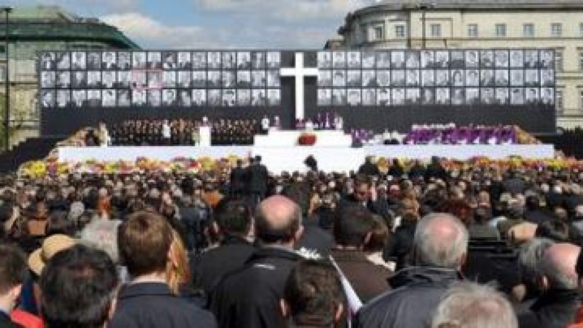 Miles de polacos despidieron ayer a las víctimas, cuyos retratos se pueden ver al fondo.