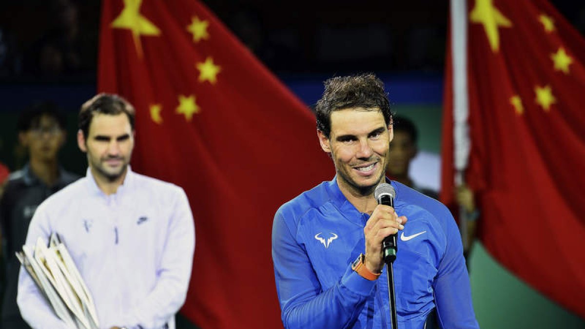 Rafa Nadal, en primer plano, felicita a Federer, detrás, después de perder la final de Shanghái contra el suizo. LIN LONG