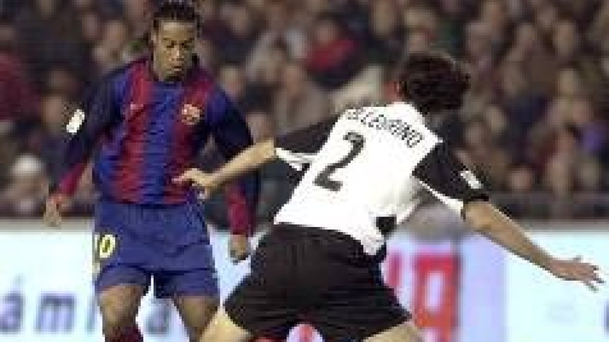 Ronaldinho trata de zafarse de la marca de Pellegrino en uno de los partidos de Valencia y Barcelona