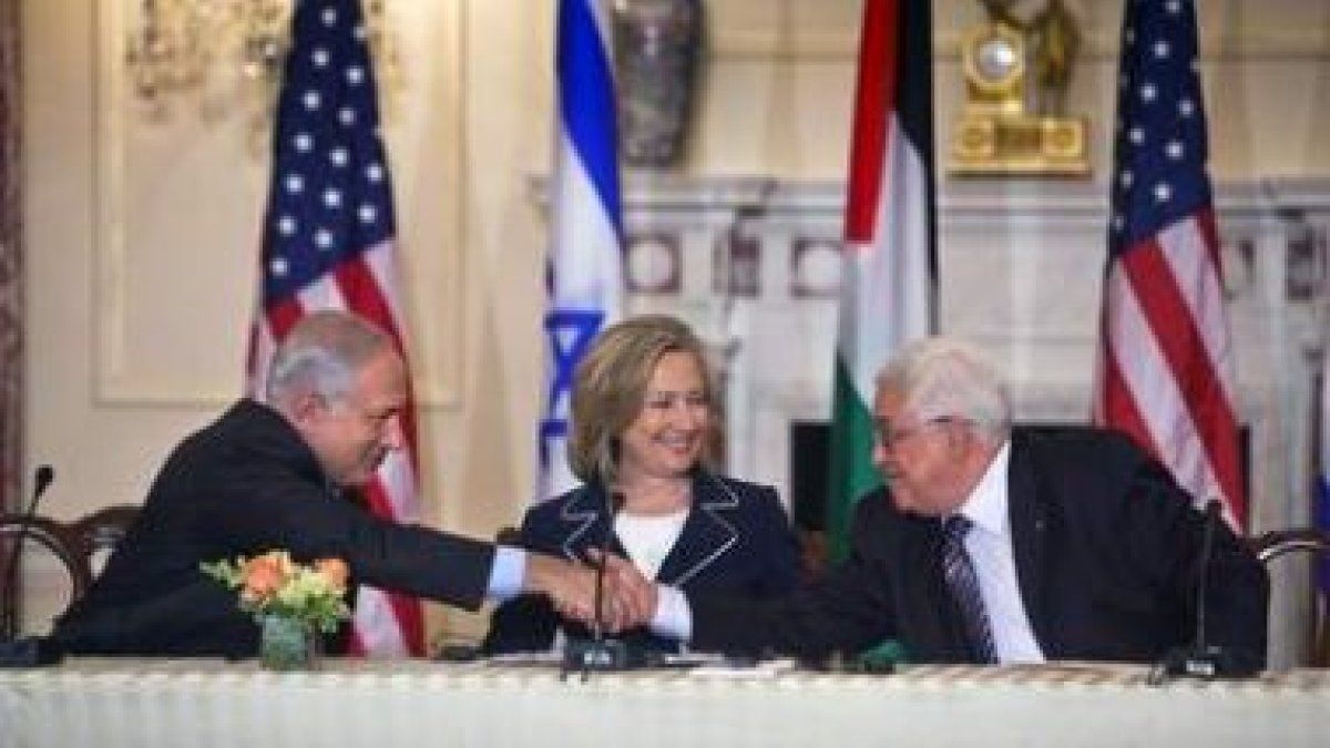 Benjamin Netanyahu estrecha la mano de Mahmud Abbas en presencia de Hillary Clinton.