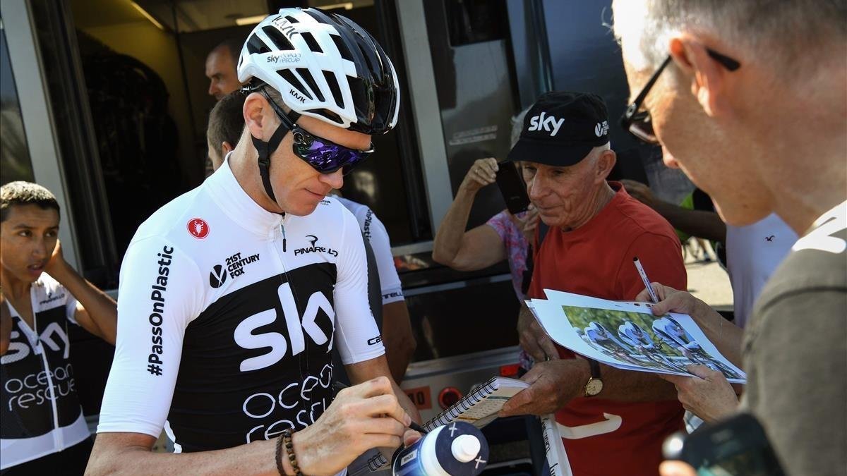 Chris Froome atiende a un aficionado, a las puertas de su hotel en Chambery.