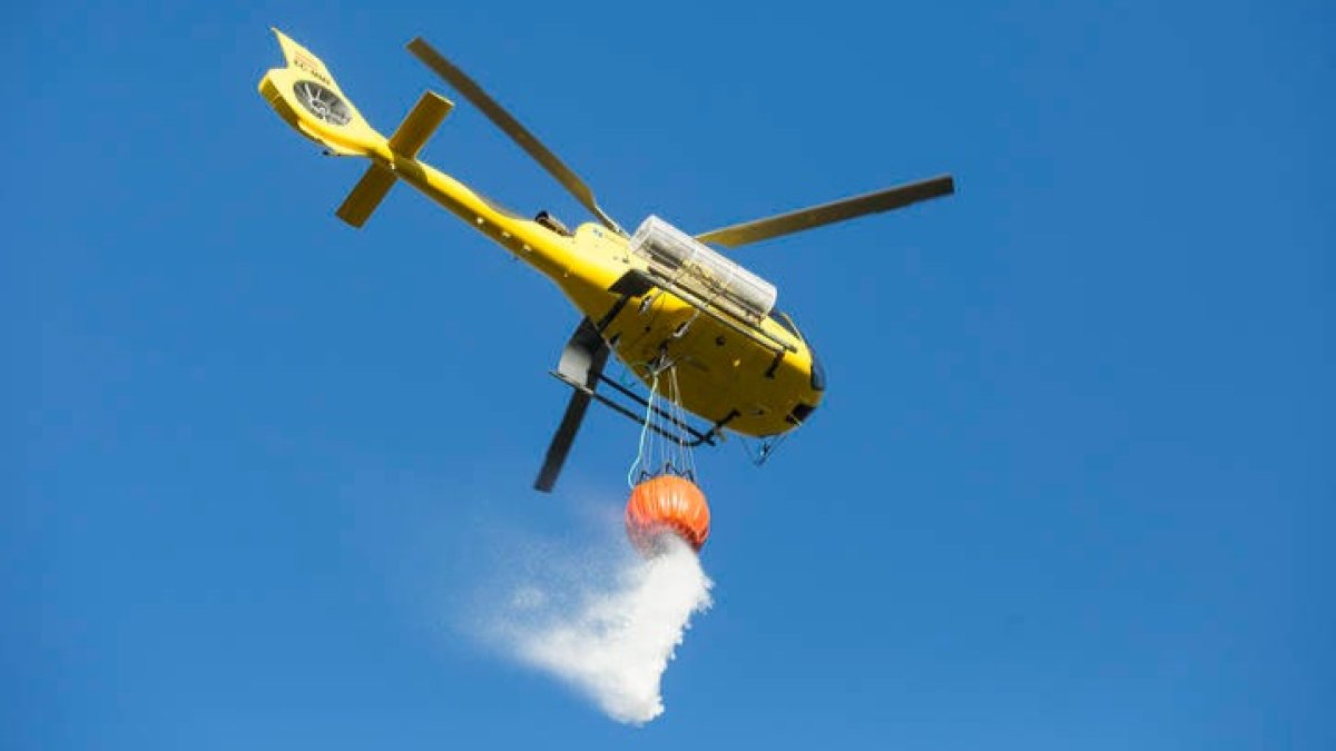 Un helicóptero suelta agua sobre un incendio en una imagen de archivo. DL
