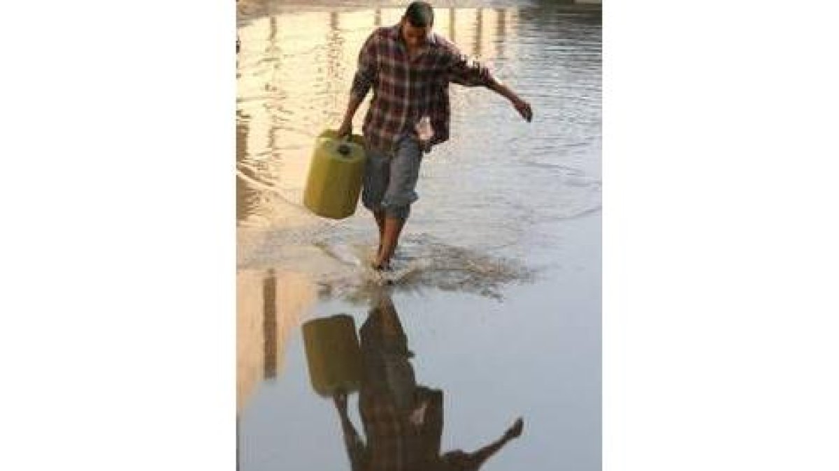 Un iraquí carga con un bidón de gasolina