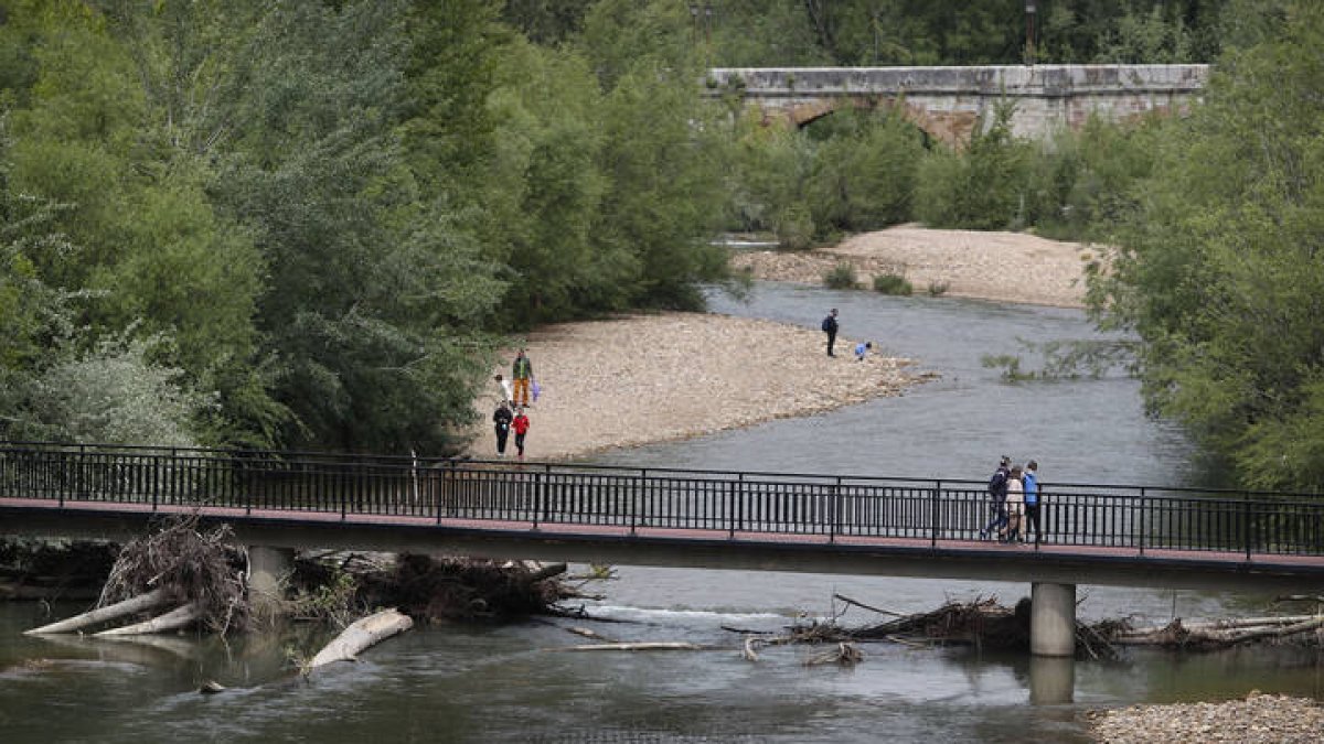 Coronavirus. Paseo mañanero con los niños por las inmediaciones del río Bernesga, con los restos de las riadas que ocurrieron en febrero.