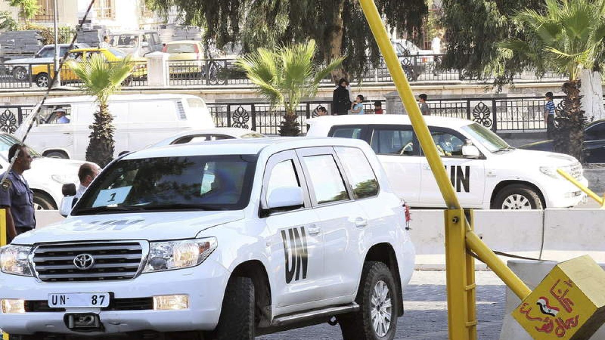 Varios vehículos de la ONU, llegando ayer a Damasco tras ser disparados durante la investigación.
