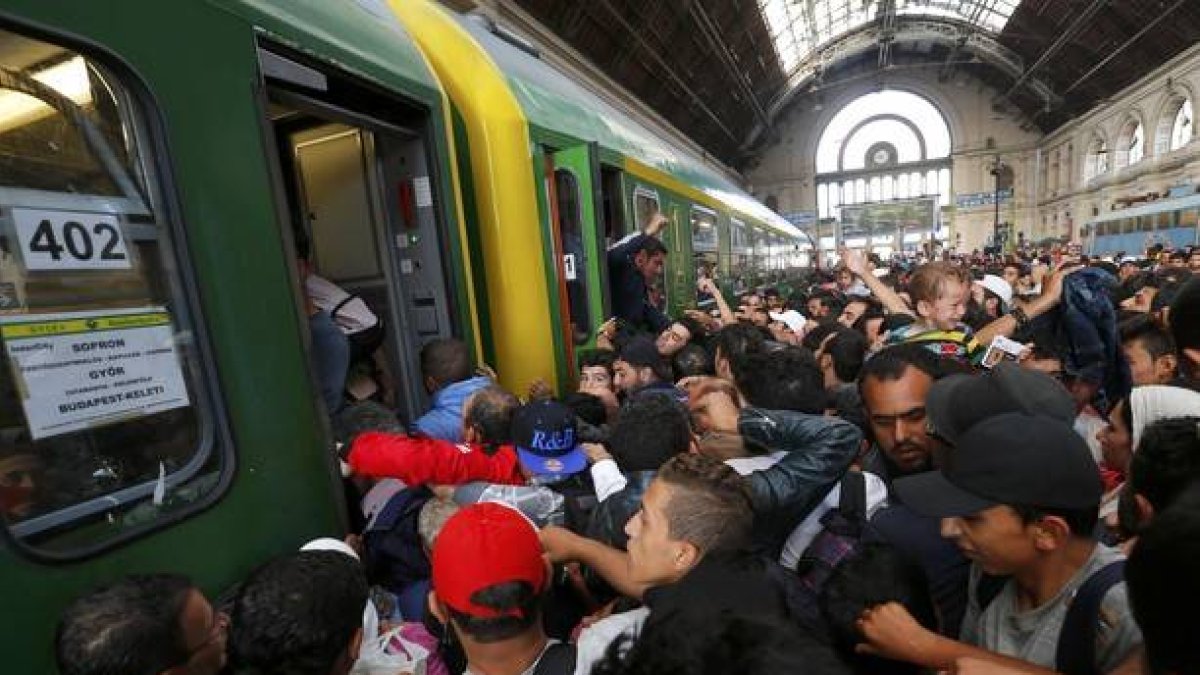 Los cientos de inmigrantes que han esperado durante dos días la reapertura de la estación de Keleti suben masivamente al primer tren.