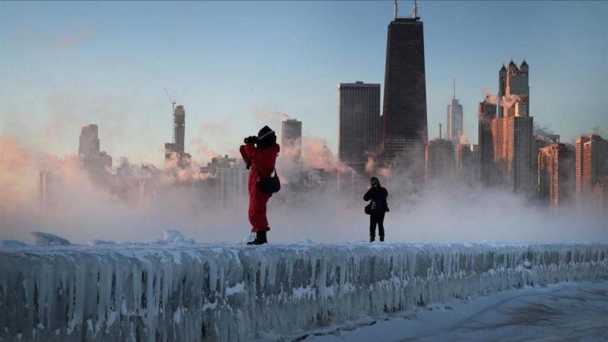 Dos fotógrafos toman imágenes de la tormenta sobre la ciudad de Chicago.