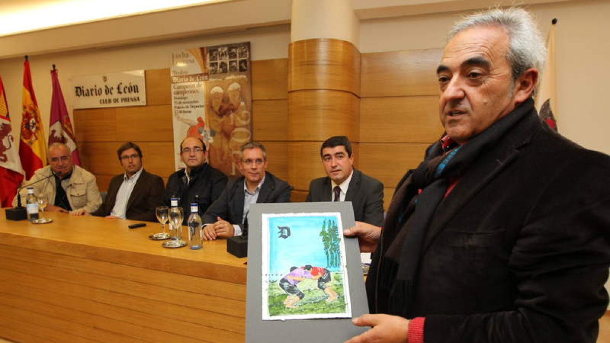 Ramón Villa, en primer plano, muestra la obra con la que se premiará a los vencedores durante la presentación del corro ‘Trofeo Diario de León Campeón de Campeones’.