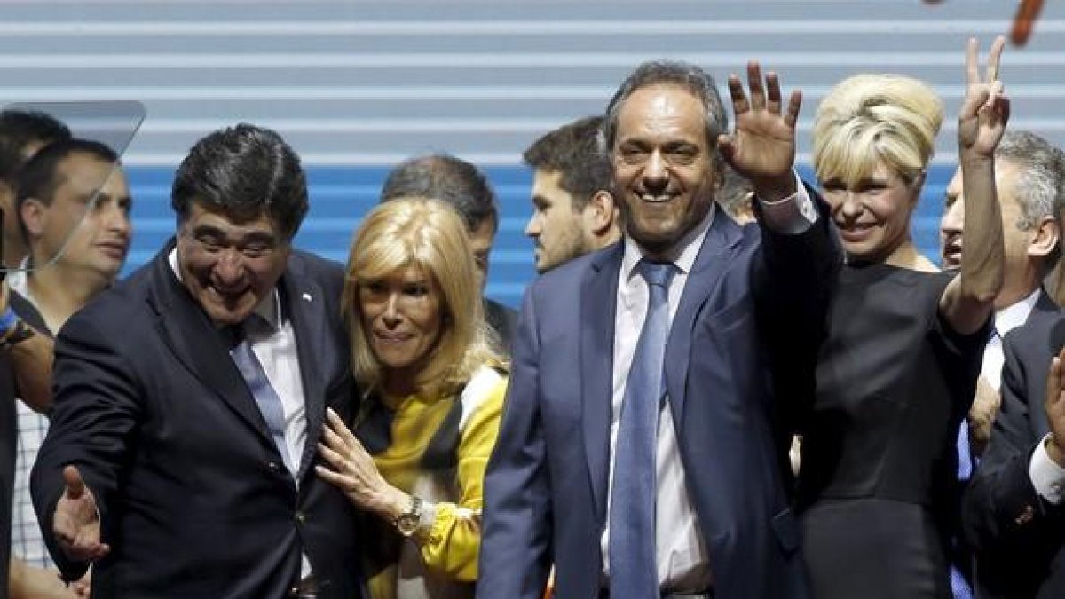 Daniel Scioli, segundo por la derecha, saluda junto a su esposa Karina Rabolini y a su candidato a vicepresidente Carlos Zannini en el acto de cierre de campaña en Buenos Aires.