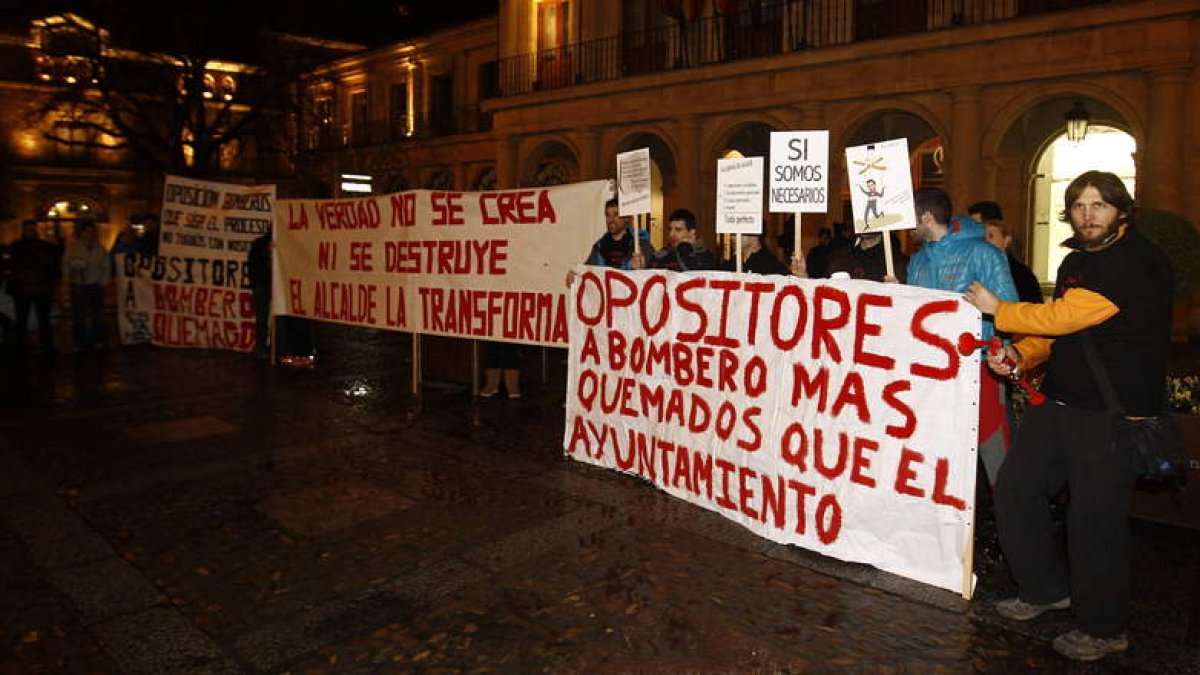 Opositores muestran sus pancartas de protesta ante el consistorio de San Marcelo.