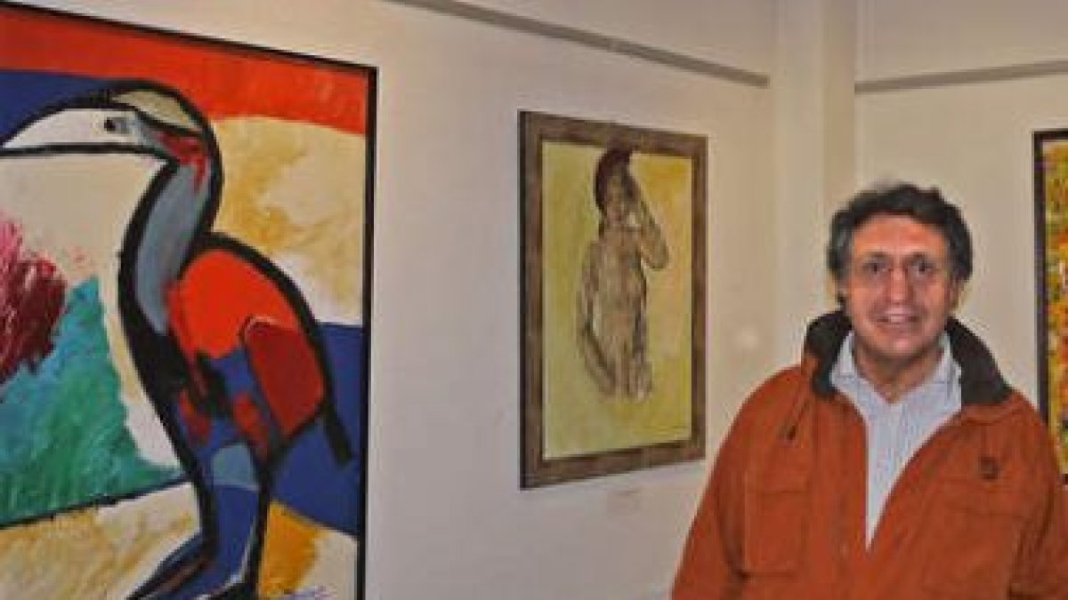 El artista Román Martínez posa con sus obras.