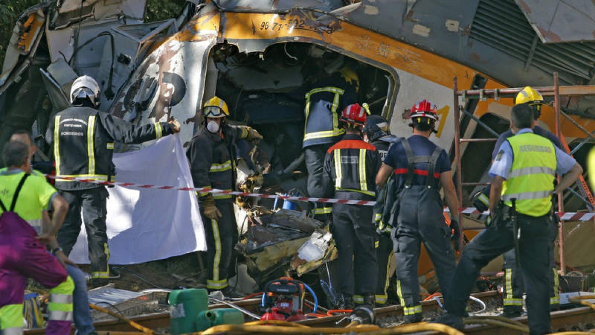 Los bomberos trabajan en el tren de la línea Vigo-Oporto que descarriló en O Porriño. LAVANDEIRA JR