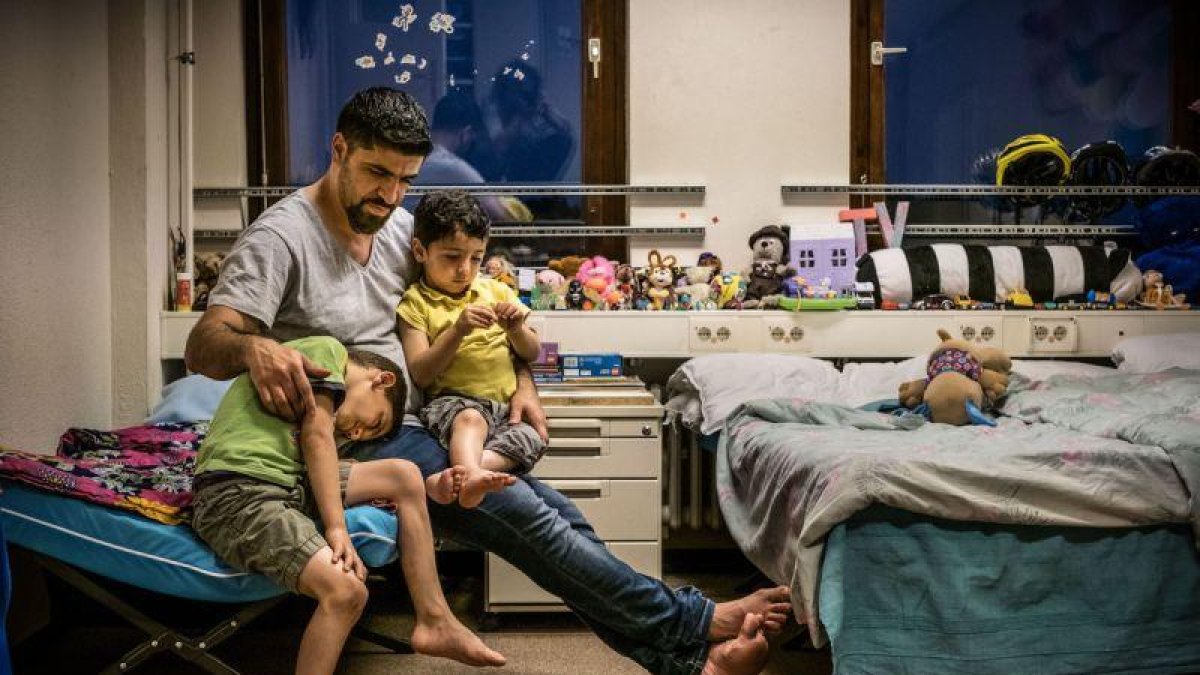 Un refugiado sirio explica cuentos a sus hijos antes de dormir, en un centro de acogida en Prenzlauer Berg (Alemania).