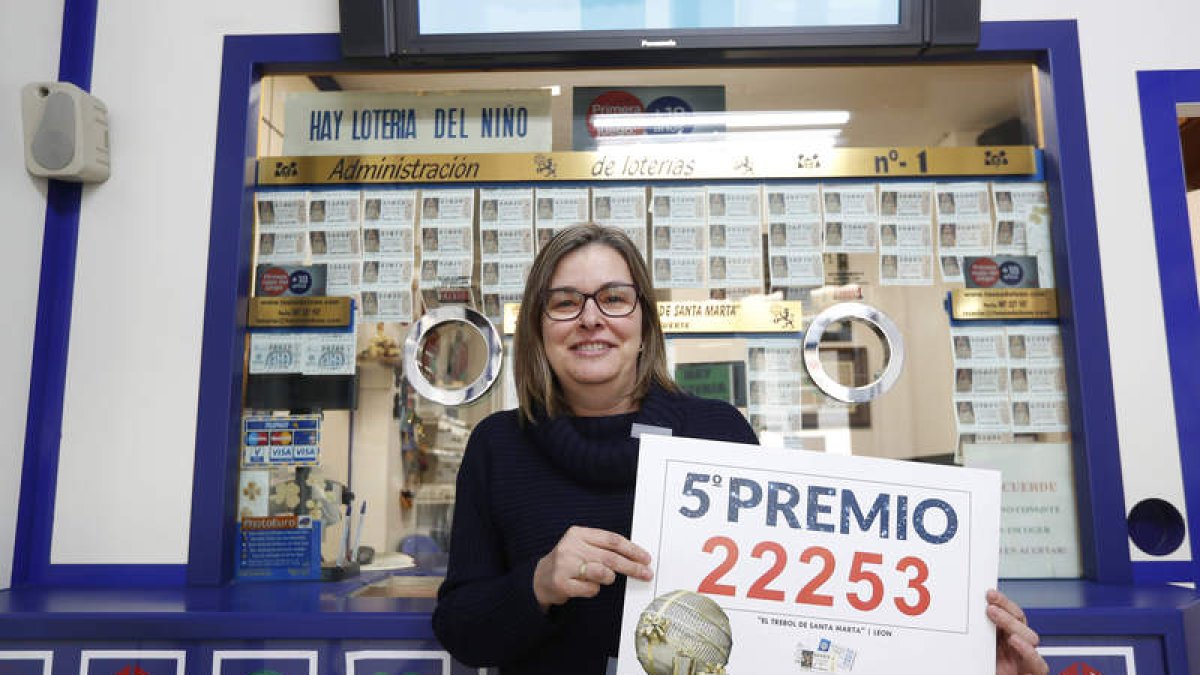 La lotera de la administración número 1 de León, en la calle Pérez Crespo, muestra orgullosa el número vendido. JESÚS F. SALVADOES