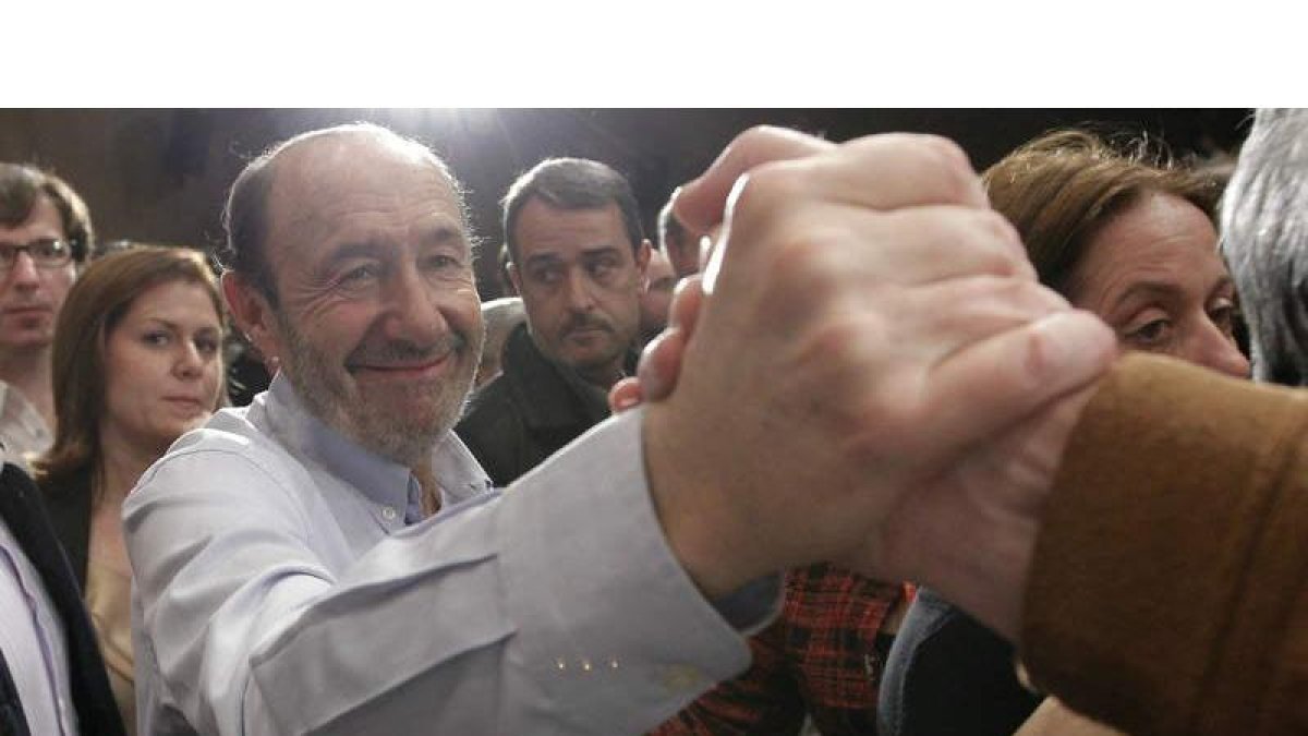 Rubalcaba recibe la felicitación de un militante después de presentar formalmente su candidatura a suceder a Zapatero en el PSOE.