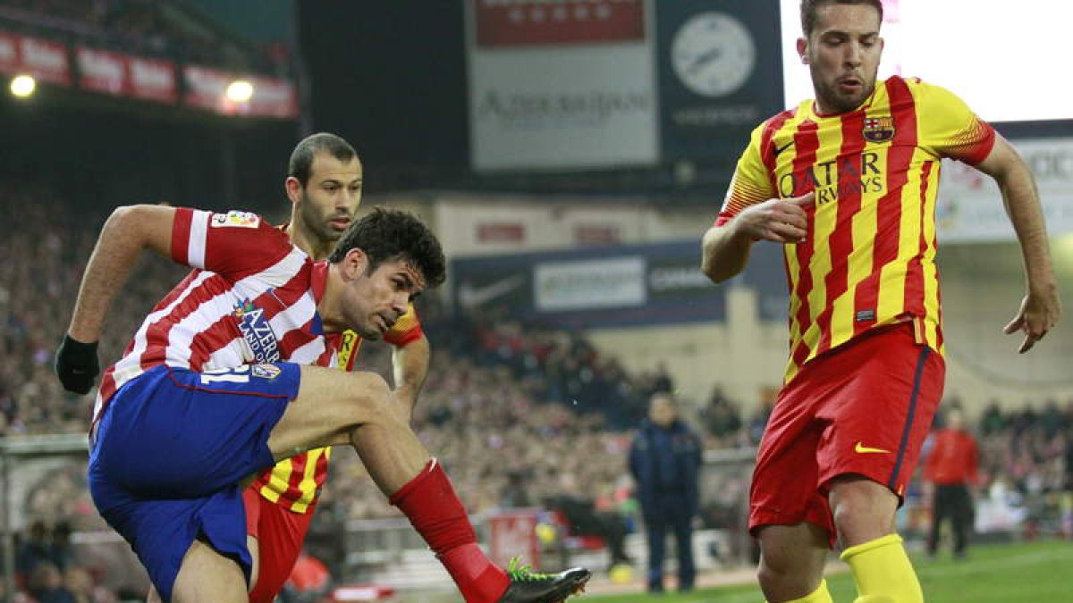 Diego Costa chuta a portería ante Jordi Alba y Mascherano, del FC Barcelona, durante el partido en el Calderón.