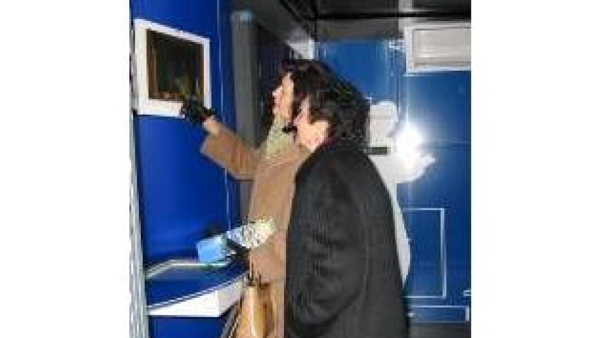 Dos mujeres consultan la información sobre Galicia disponible en la exposición