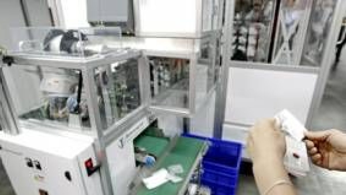 Una farmacéutica revisa los fármacos que produce una robot en un laboratorio