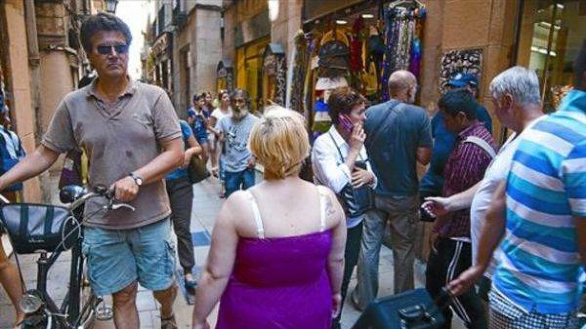 Paseantes y compradores, en una de las pequeñas y concurridas calles del Gòtic.