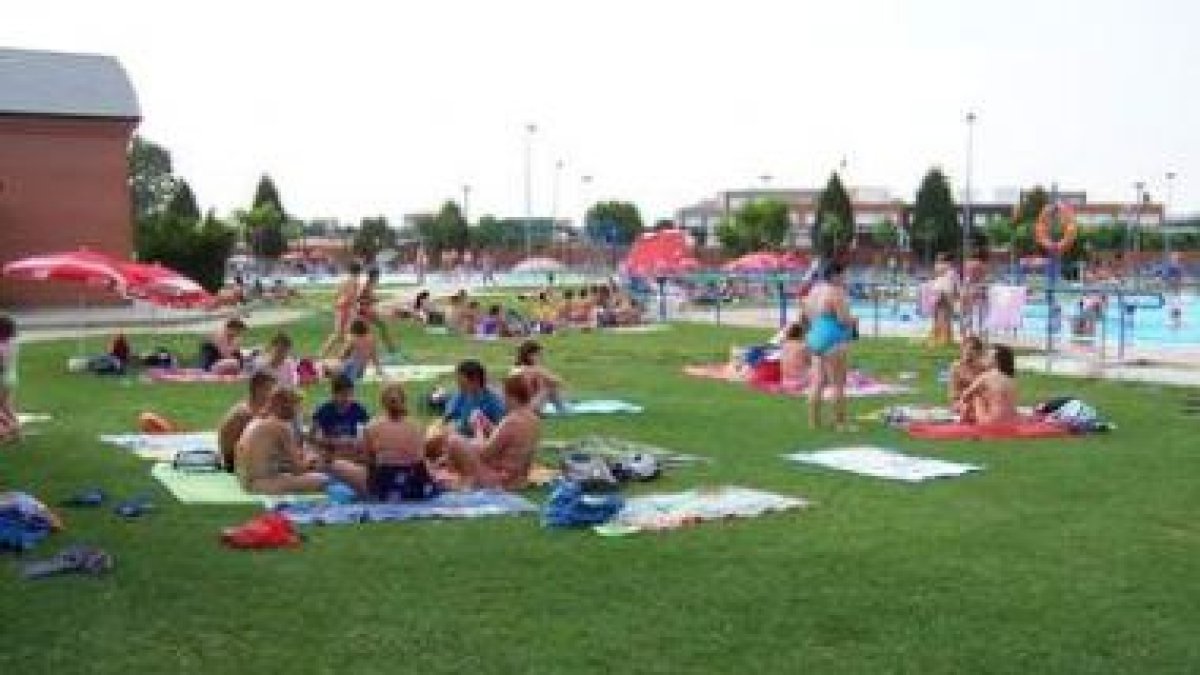 Bañistas disfrutan de una calurosa tarde de agosto en las piscinas de Trobajo.