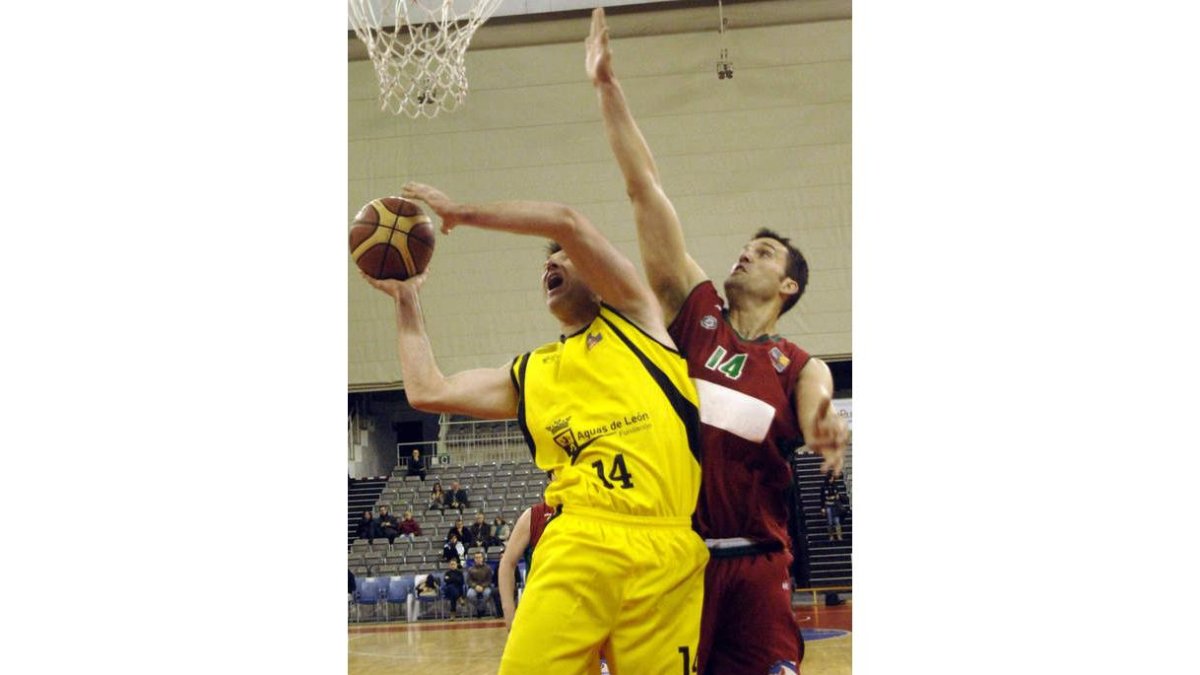 El pívot del Granada Coego intenta taponar una acción ofensiva del alero gallego de Baloncesto León Julio González.