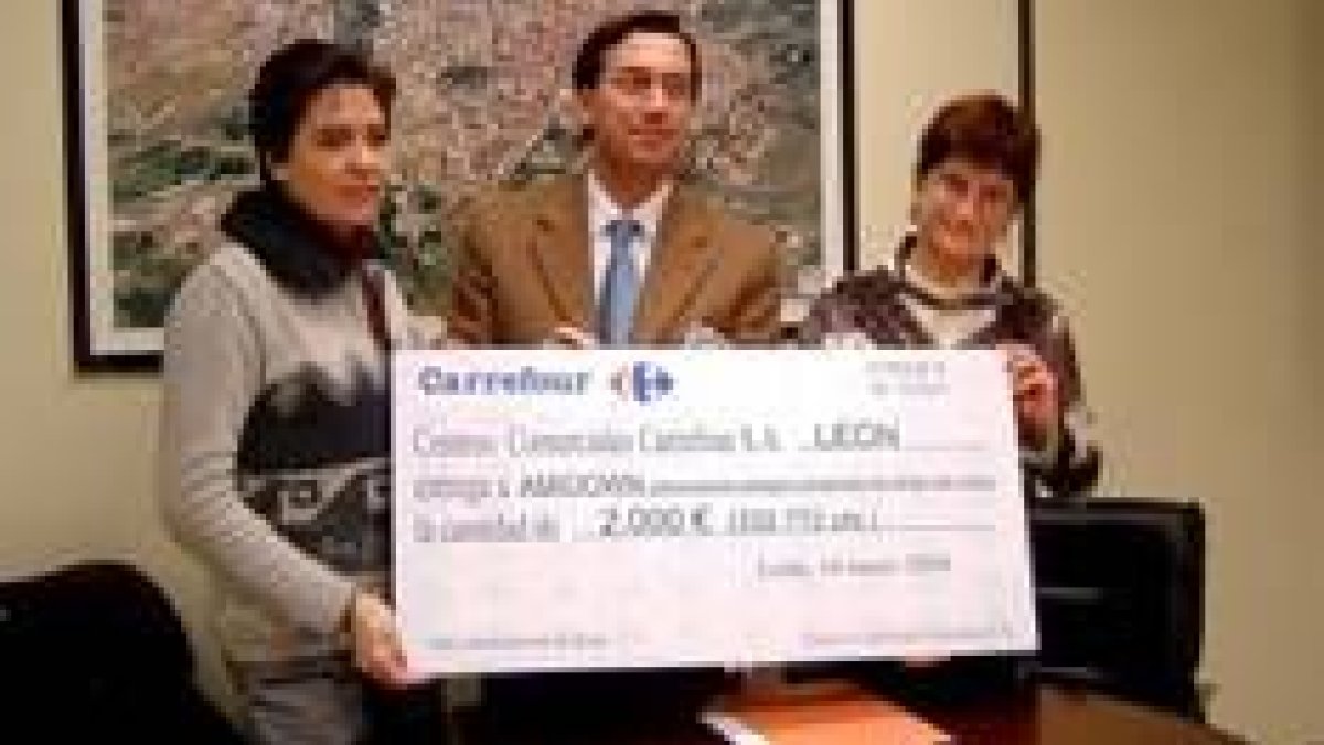 El director de Carrefour en León, Antonio Márquez , hace entrega del cheque a Amidown