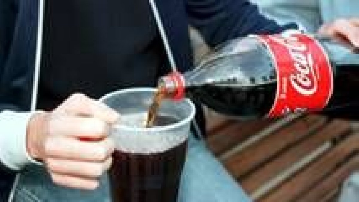 Un joven mezcla una bebida alcohólica con cola para «hacer botellón»