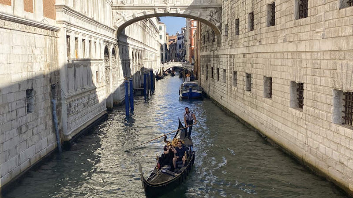 Una pareja disfruta de un viaje en góndola por un canal de Venecia. ANTONELLO NUSCA