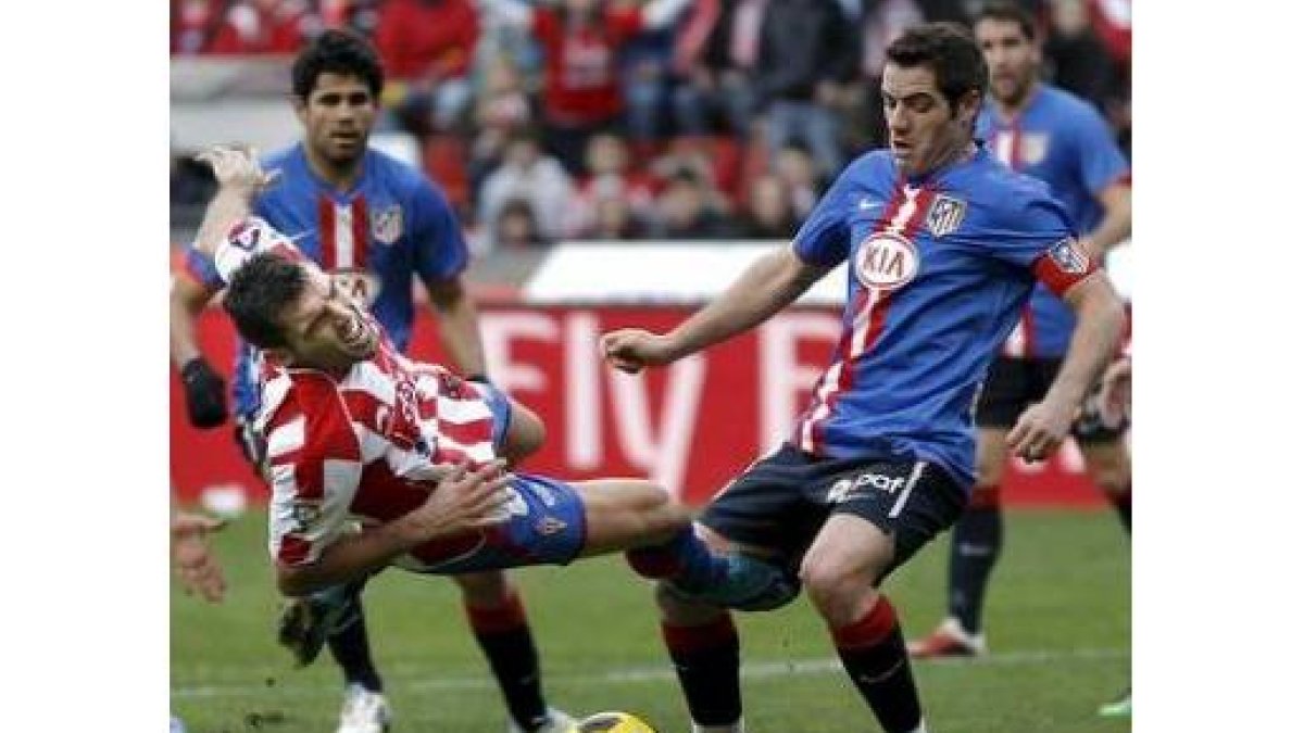 Barral cae en el área rival ante el defensa del Atlético de Madrid Antonio López.