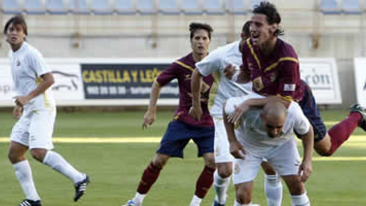 Un defensor del equipo granate salta sobre el culturalista Jito impidiendo el remate de éste con la