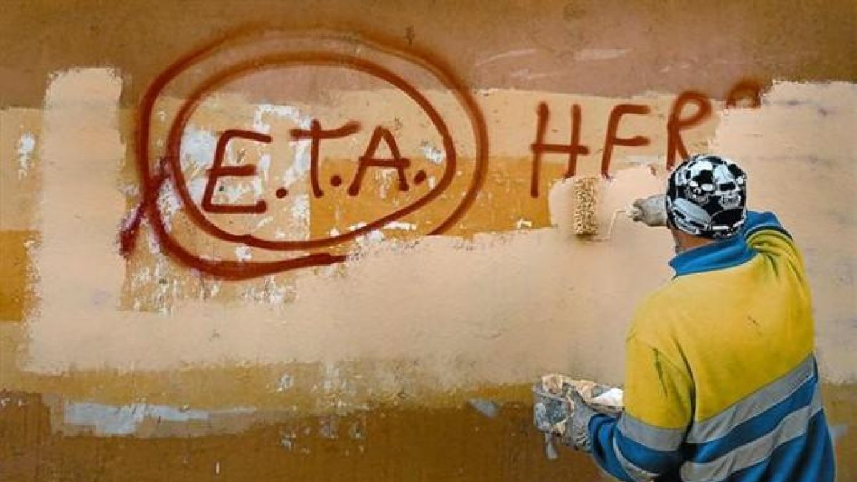 Un técnico de limpieza borra una pintada a favor de ETA en Gernika (Vizcaya), el día después de que la banda terrorista anunciase el cese definitivo de sus acciones armadas.