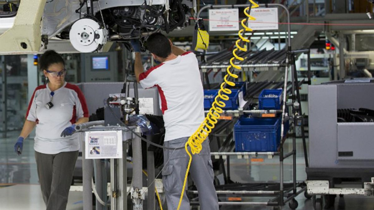 Un hombre y una mujer en una cadena de montaje de Seat.