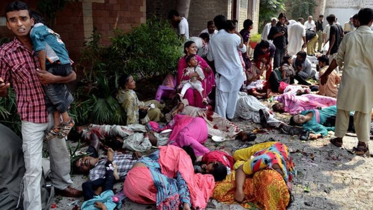 Ciudadanos pakistanís socorren a víctimas del atentado suicida de Peshawar.