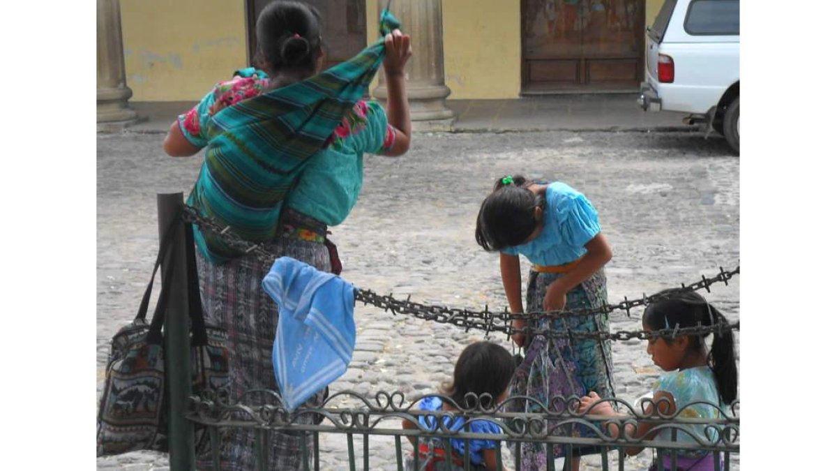 Una mujer y sus hijas en la Plaza Central en Antigua y cementerio de Chichicastenango, en Guatemala. A la derecha, Camino Llamazares en el mercado de Santo Tomás y, abajo, en una comunidad indígena.