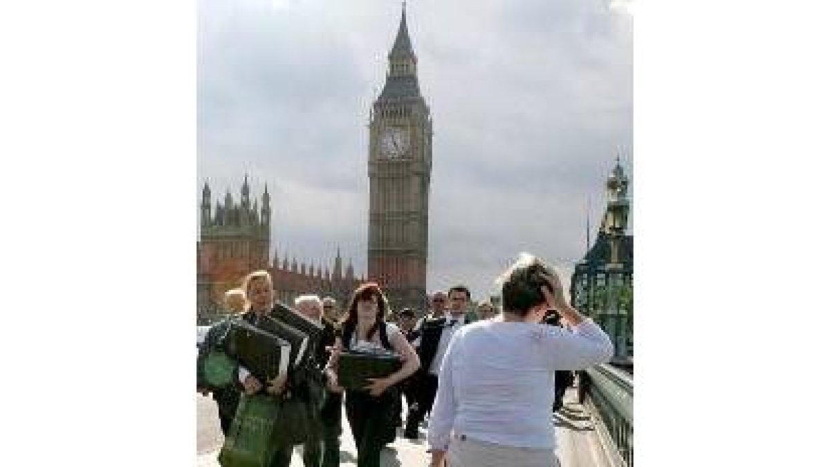 Londinenses, desconcertados, atravesando el puente de Westminster