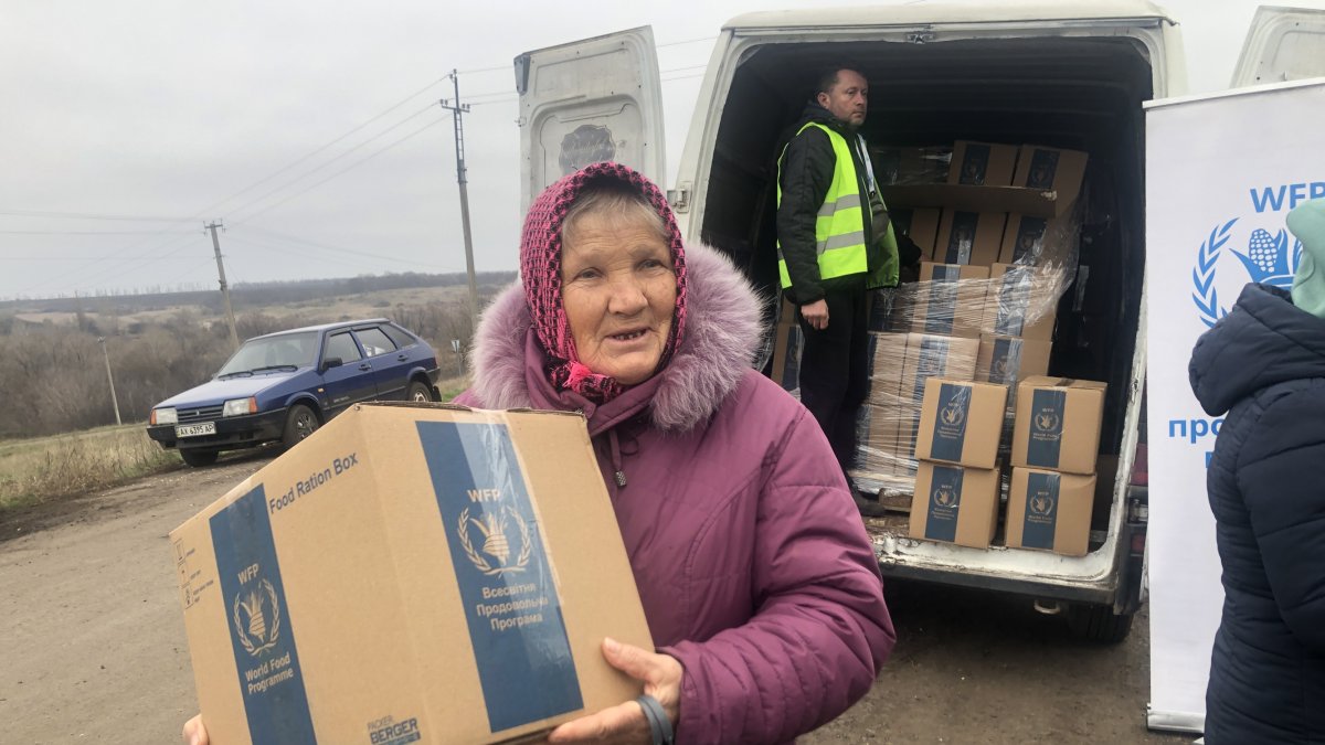 Maria Fediuk, de 79 años, con su caja de doce kilos y medio. GERVASIO SÁNCHEZ