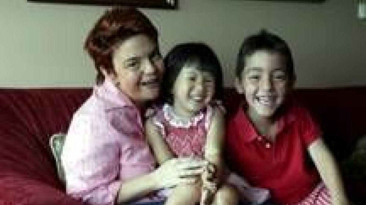 En la imagen una mujer española que adoptó a dos niños, un español y una niña china