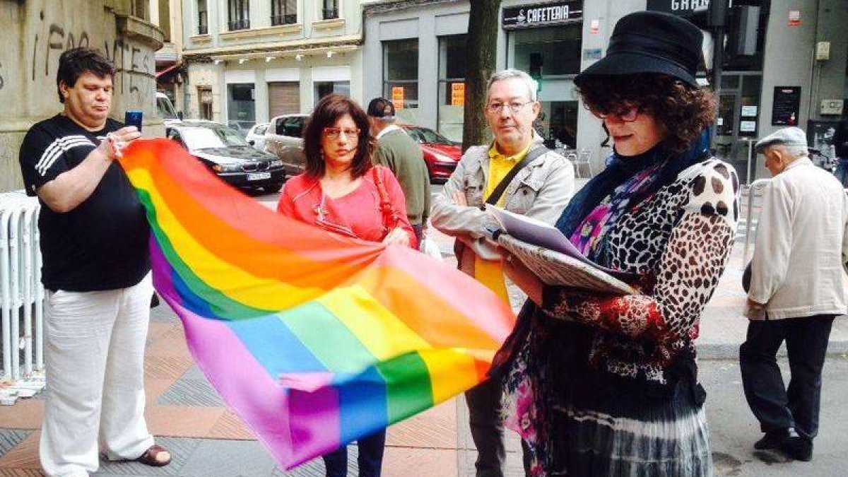 Representantes sindicales, políticos y colectivos gay despliegan la bandera multicolor antes de izarla en la sede de los sindicatos en León para conmemorar el Día del Orgullo Gay