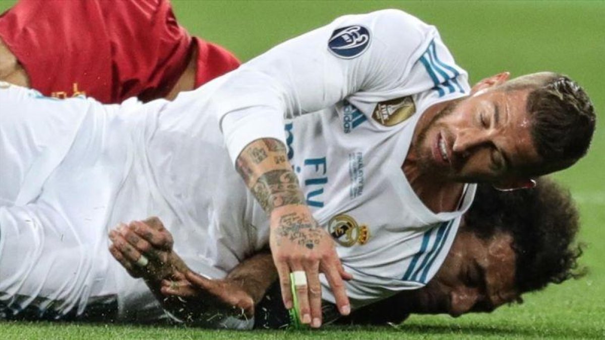 Sergio Ramos cae sobre Salah tras la disputa de un balón y le lesiona.