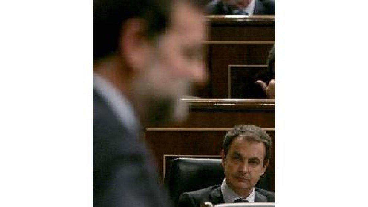 El presidente Zapatero escucha a Rajoy el día del Pleno extraordinario