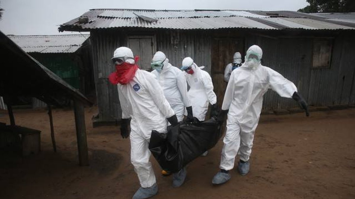 Un equipo médico carga con un cadáver afectado por el ébola en Liberia, el pasado agosto.