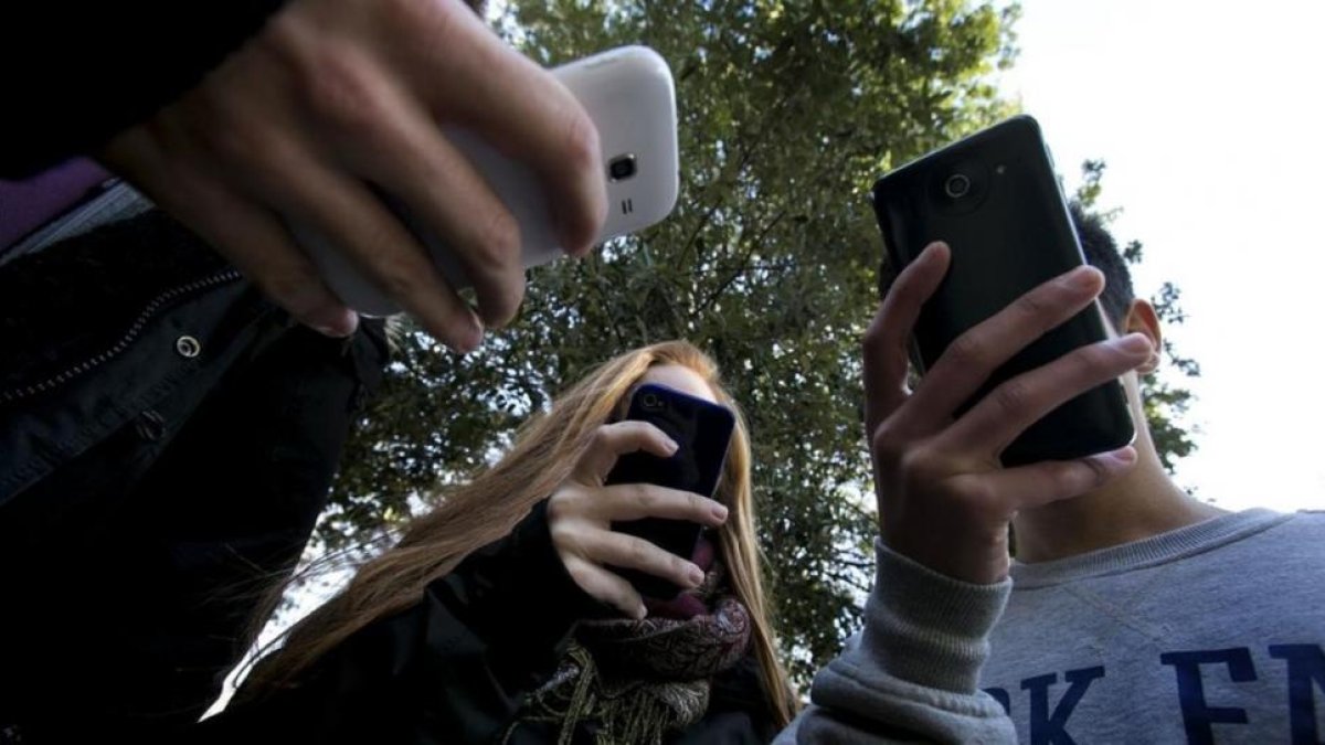 Adolescentes utilizando teléfonos móviles.