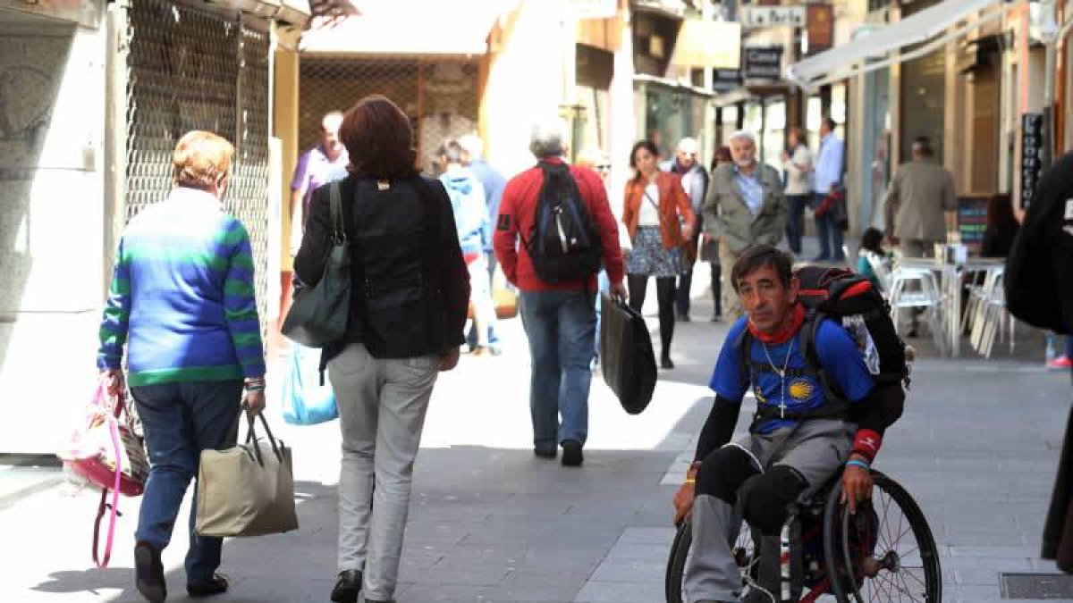 Un peregrino con discapacidad, transita por una céntrica calle de la ciudad.