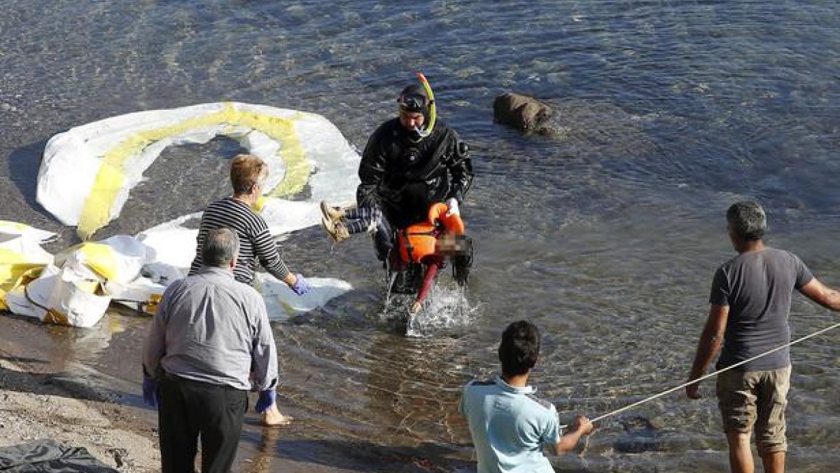 Un guardacostas griego saca del agua el cadáver de un niño refugiado en la costa griega de Lesbos.