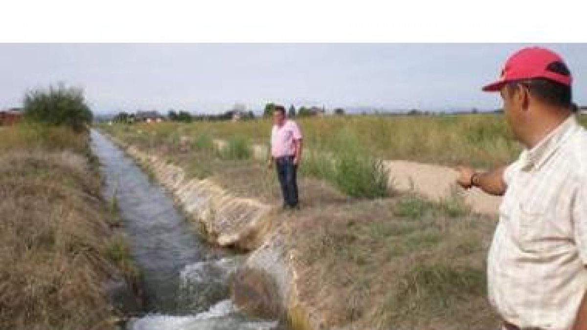 El guardia del agua señala uno de los múltiples lugares donde la acequia del canal está fracturada.