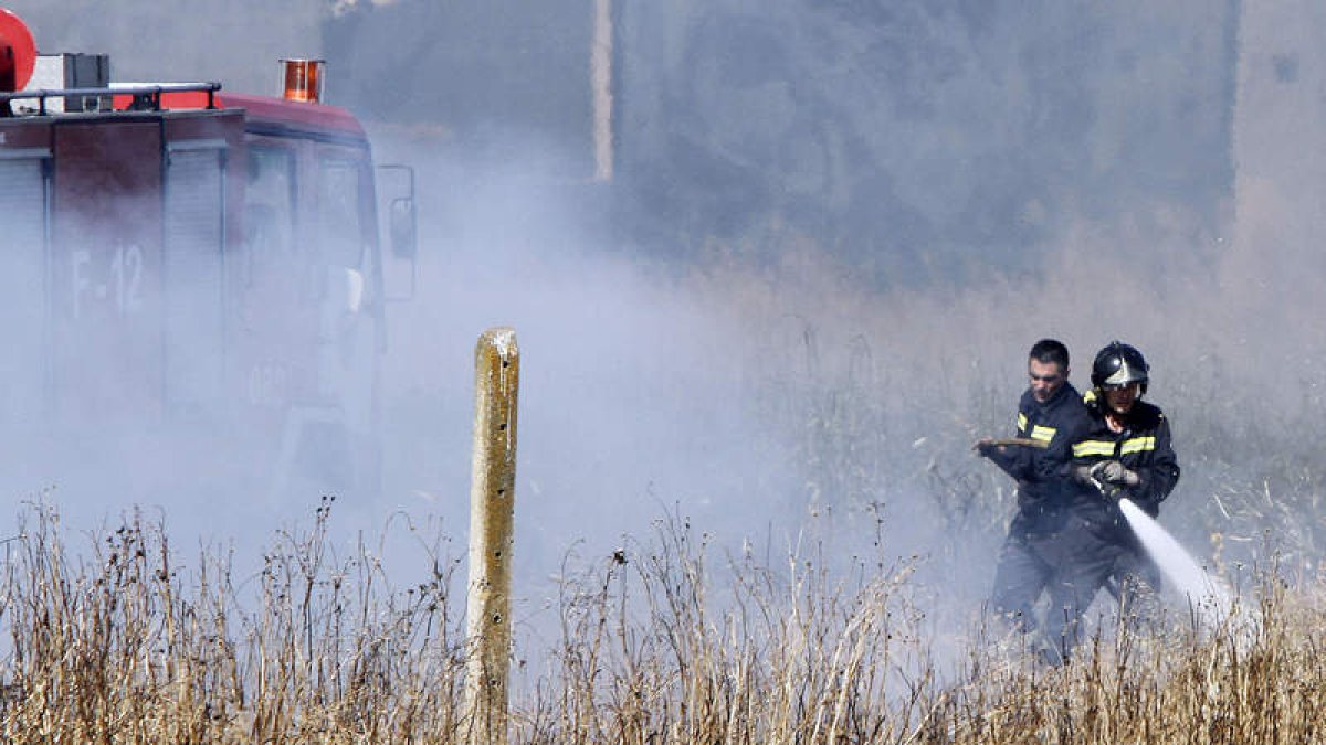 Los bomberos, en plena acción, para tratar de combatir las llamas.