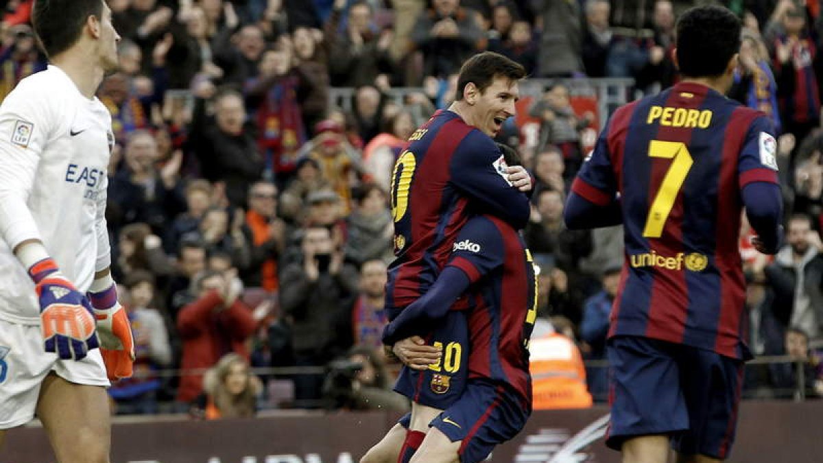 Messi celebra con Bartra uno de sus tres goles, ayer, frente al Levante.