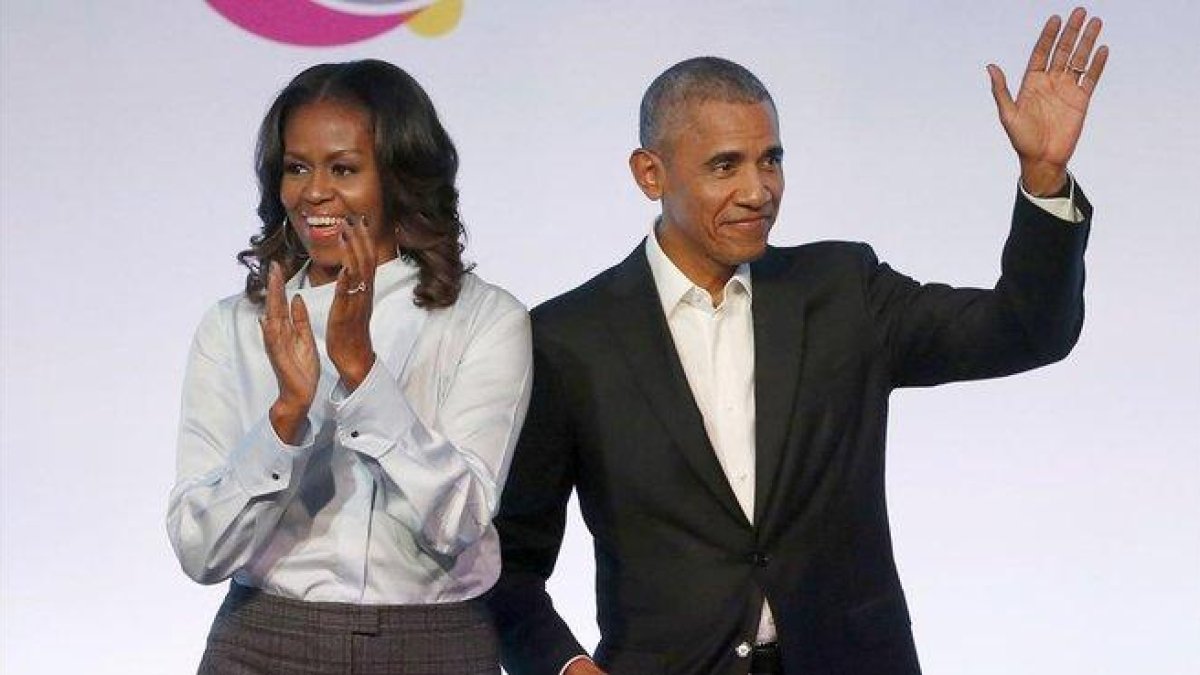 El matrimonio Obama posa sonriente tras firmar el acuerdo con con la plataforma de música en streaming Spotify.