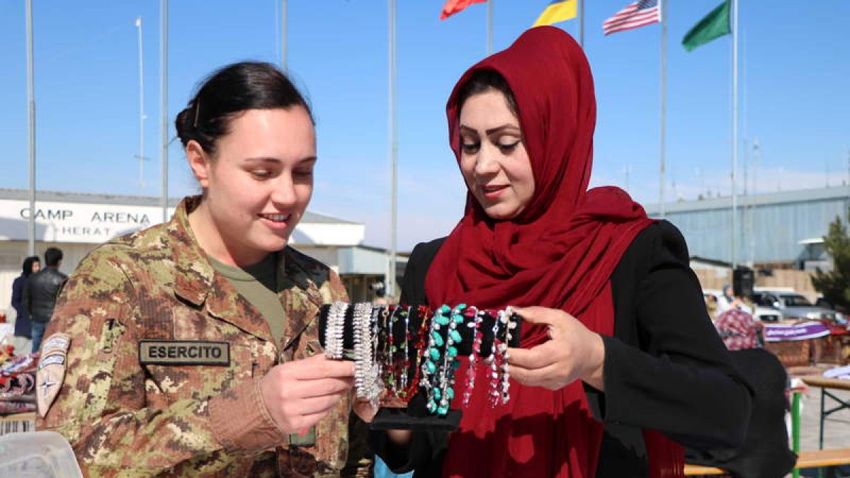 Una militar italiana y una afgana en el mercado artesanal organizado con el apoyo de la OTAN en Herat.  JALIL REZAYEE